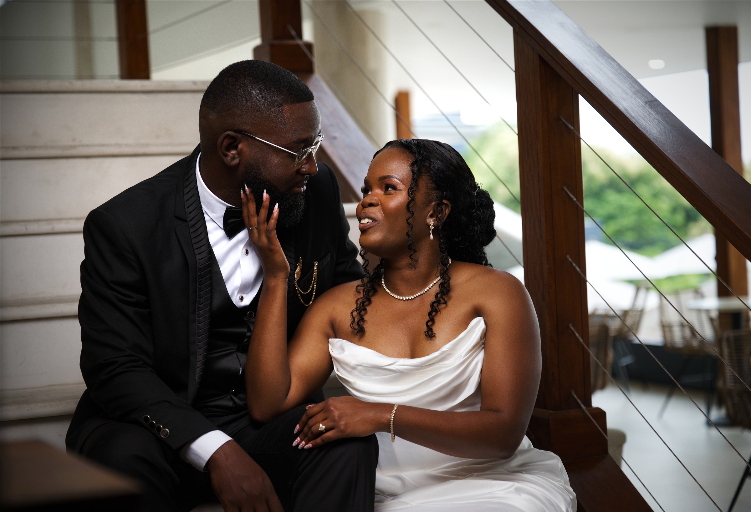 A newly married couple sharing a quiet moment on a staircase, photographed by ZAH Media