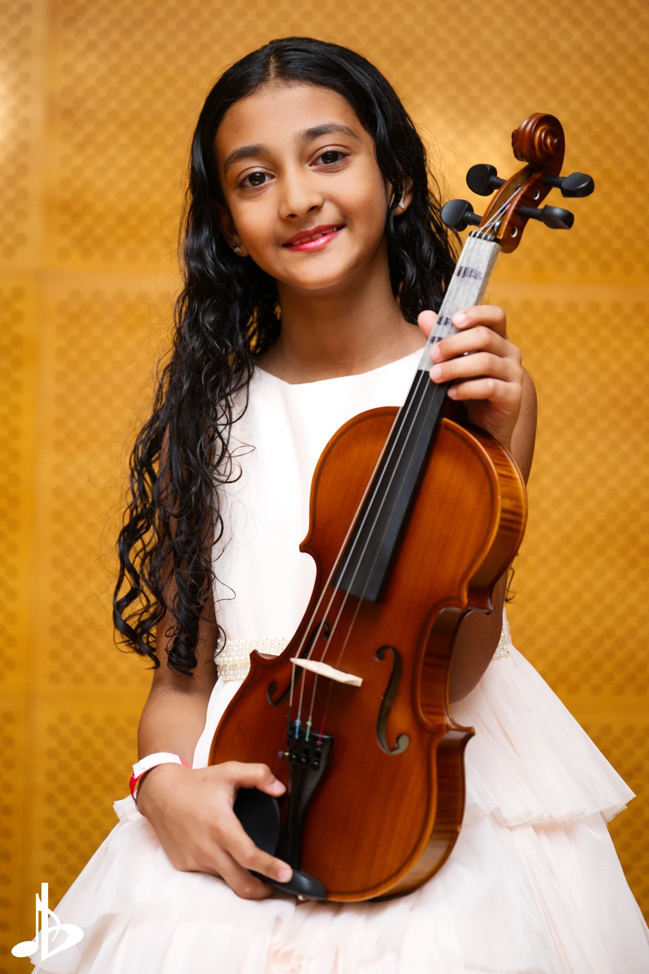 A violinist in white posing for a Laudem recital portrait